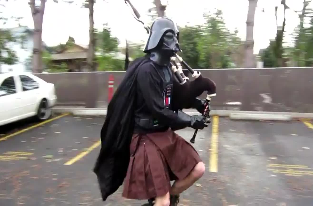 Darth Vader in a kilt and on a unicycle playing the bagpipes.
