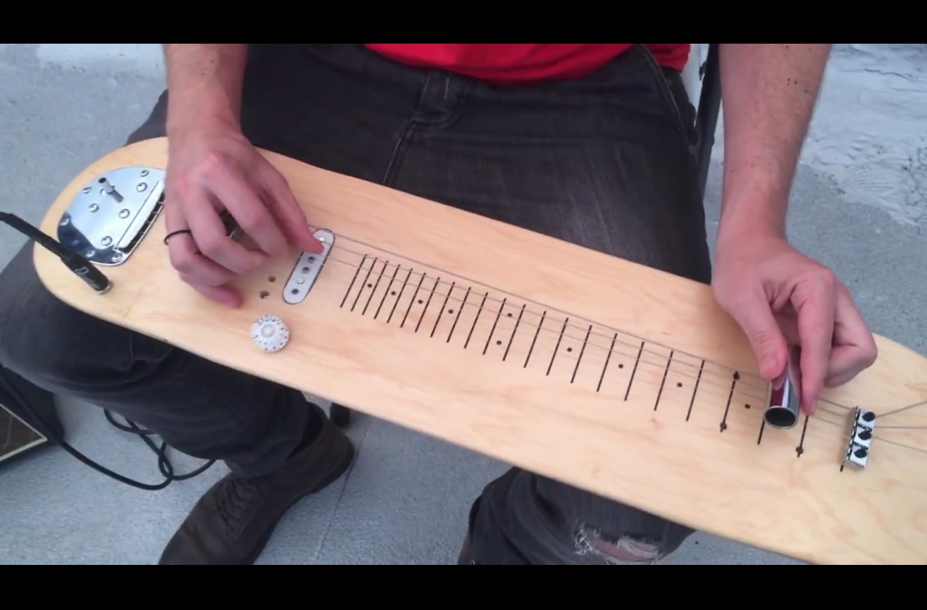 A guitar made from an old skateboard.