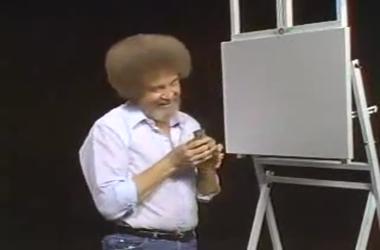 Bob Ross kneeling to feed a small squirrel from his hand, surrounded by autumn leaves