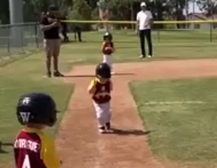 Little kid runs in slow motion during baseball game.