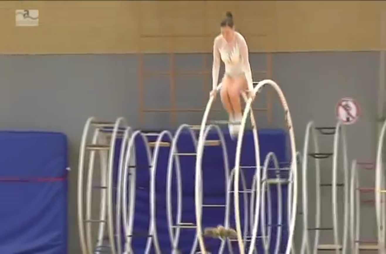 Gymnast uses giant hoops to put on an excellent performance.
