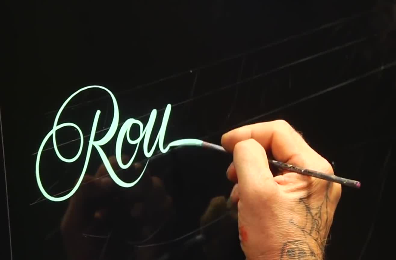 Master pinstriper demonstrates roundhand lettering.