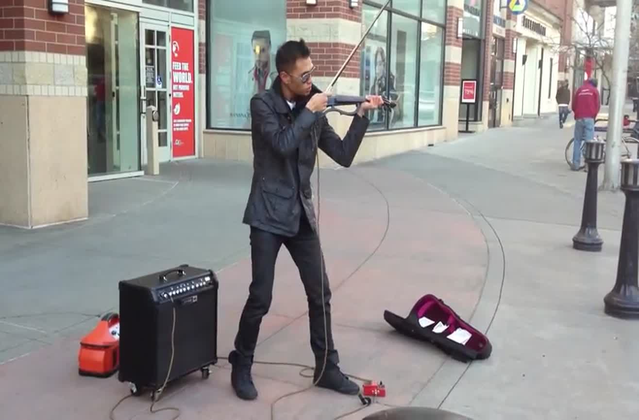 Street musician plays electric violin.