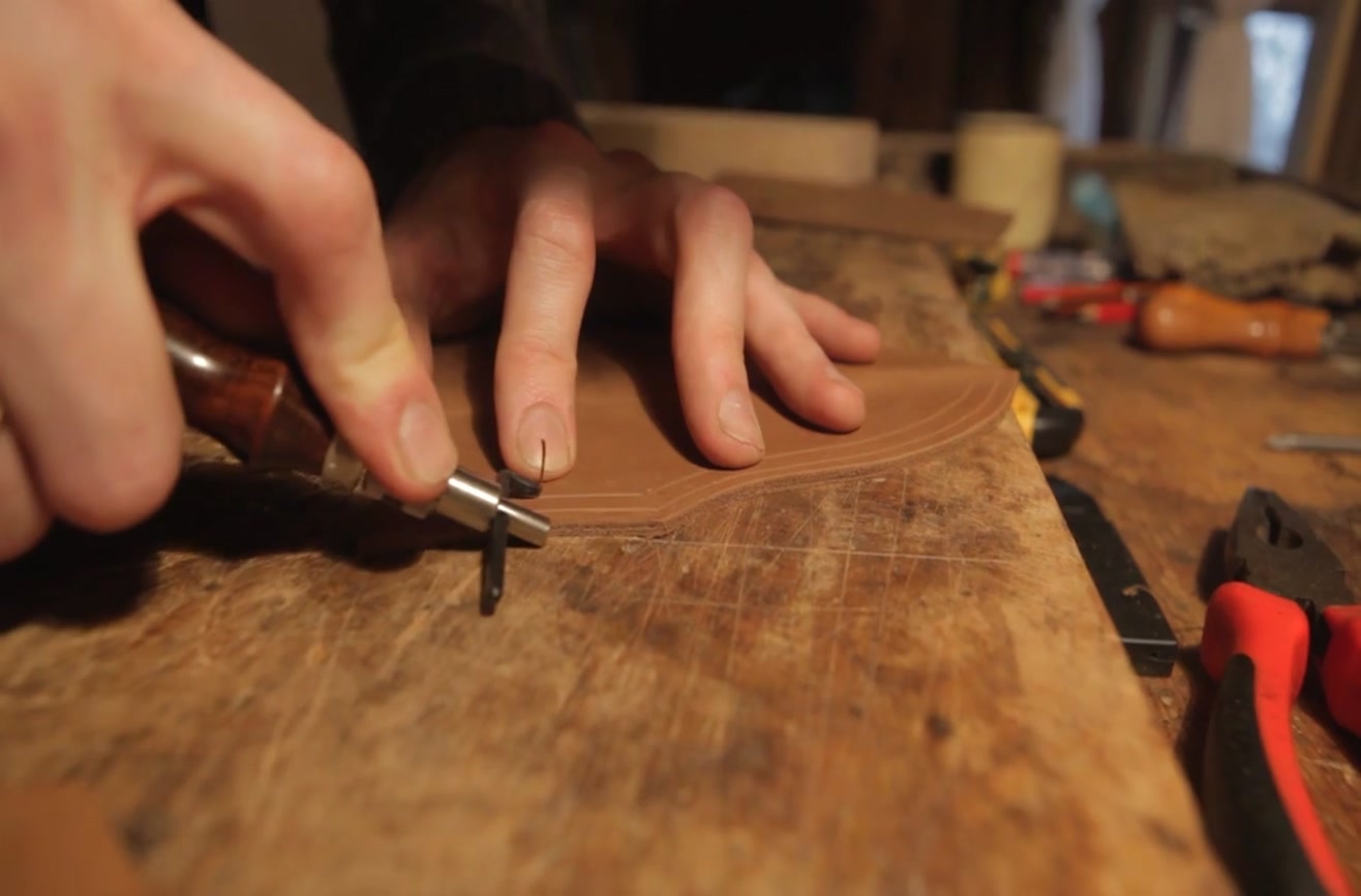 An intermediate bladesmith forging a pattern-welded knife on a large anvil