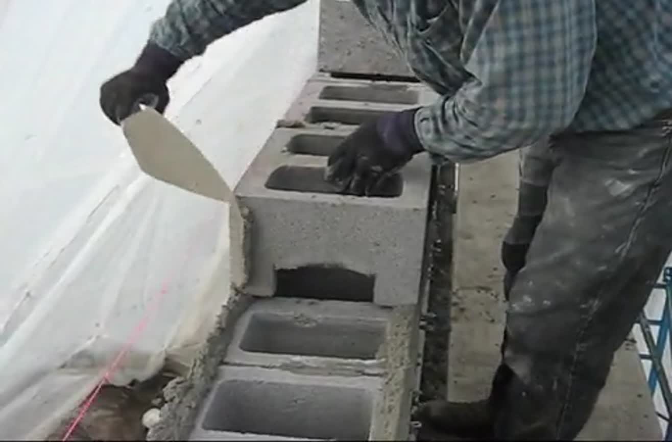 Laying cinder blocks like a pro.