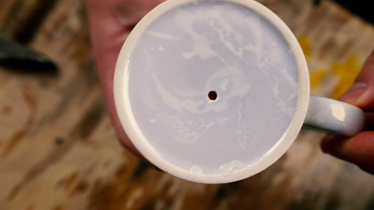 An odd way to make a hole in a coffee mug.